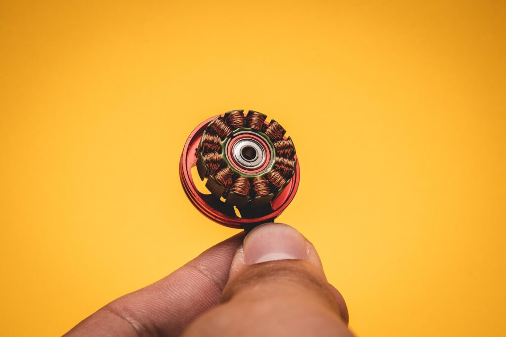 Person holding an open drone electric motor with it's copper coils and magnets